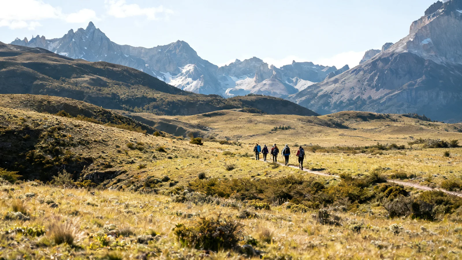 Distant guided walkers crossing a wide southern mountain valley in natural light